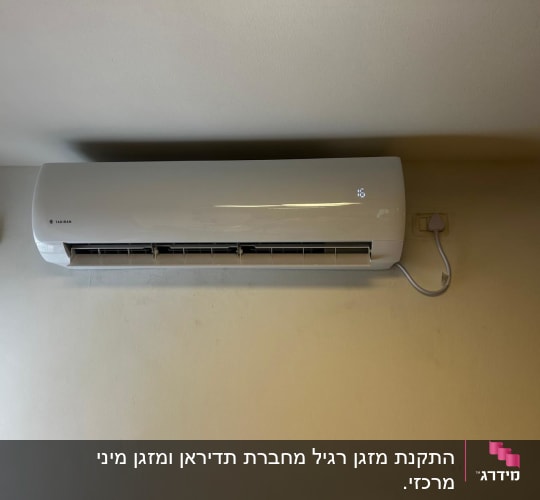 מזגן מותקן על קיר עם חיבור לחשמל